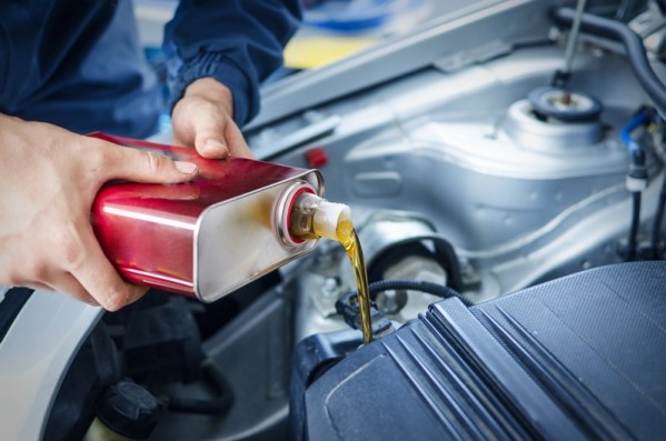 mechanic changing engine oil on car vehicle